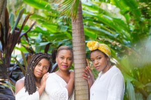 Three black women stare in southern/tropical environment
